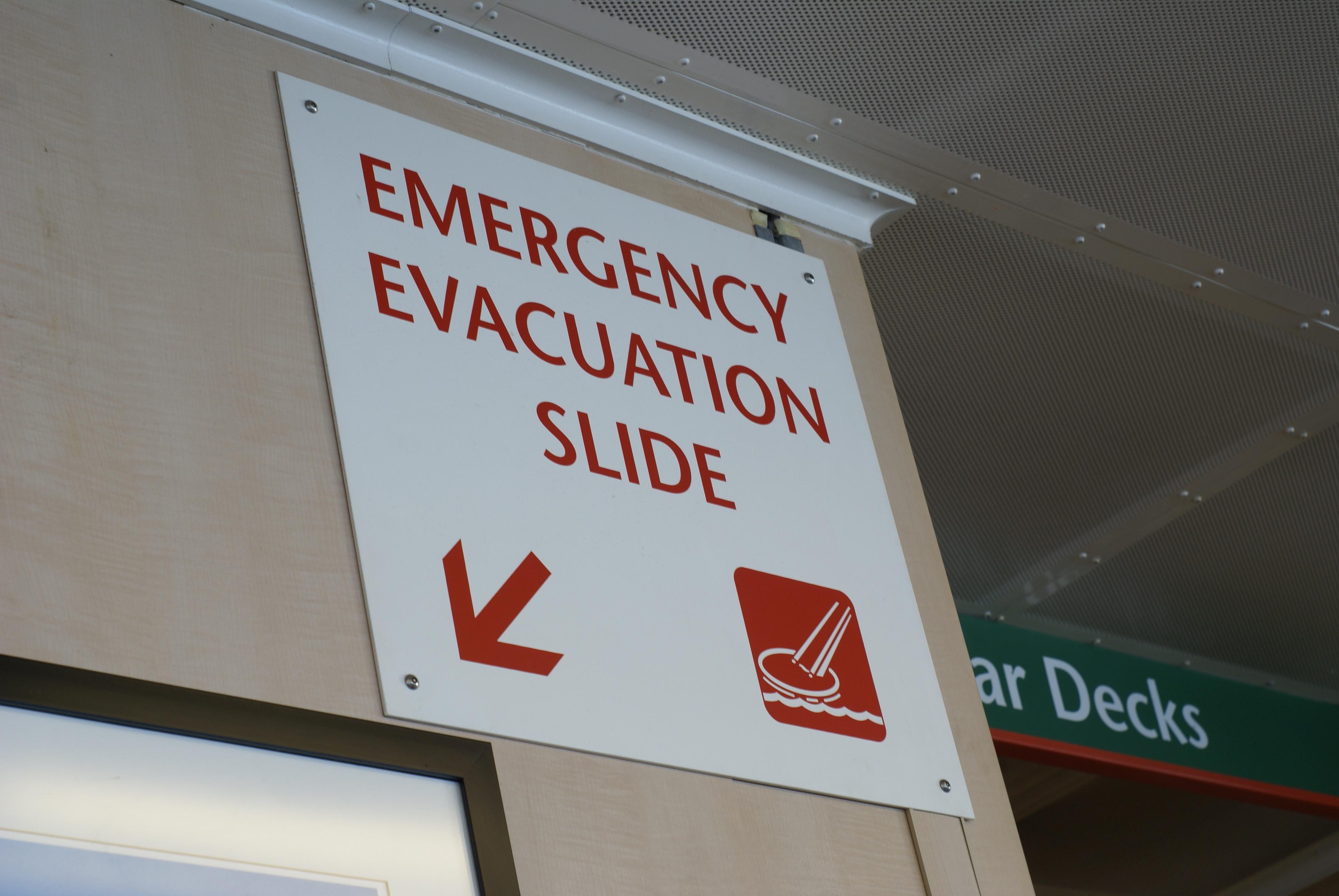 Sign pointing to the emergency evacuation slide of a ship.